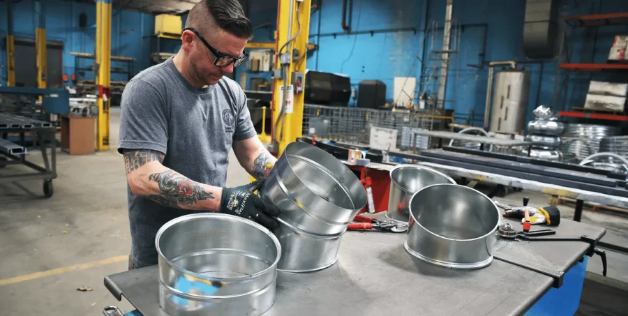 Roth associate with tattoos working on HVAC equipment