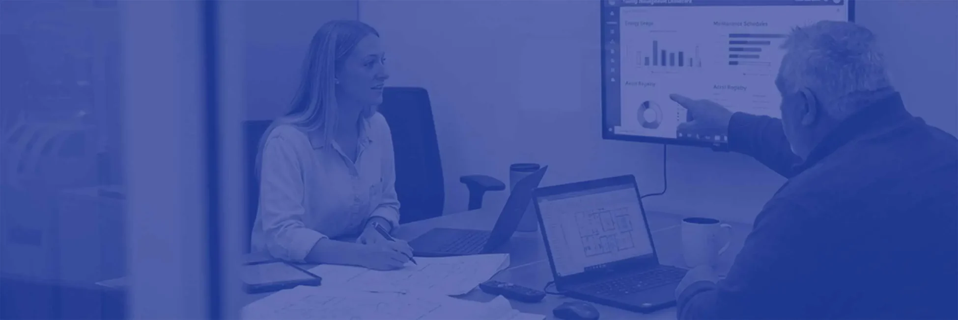 man and woman working on laptops in an office