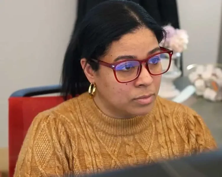 woman with glasses working on her computer